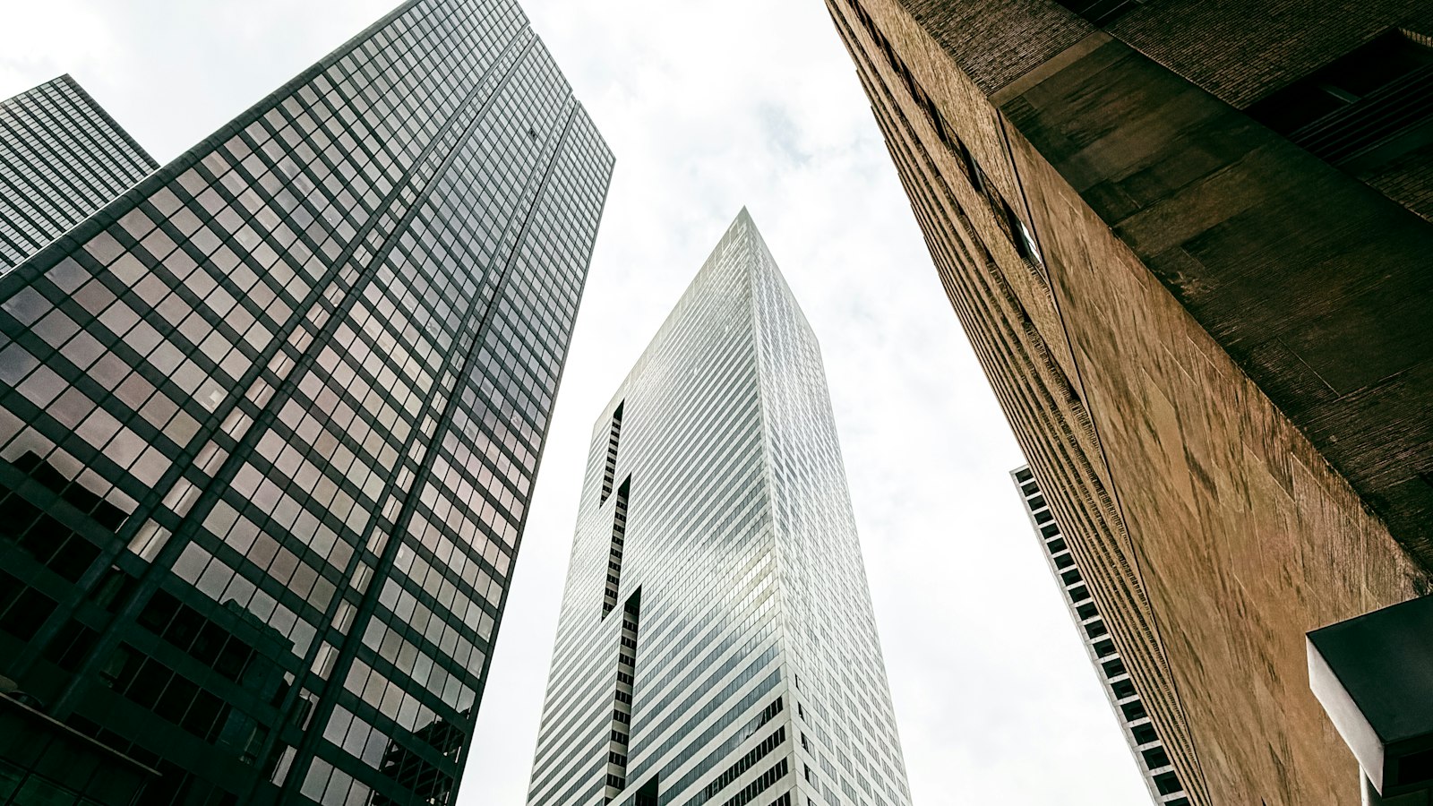 Tall glass and concrete skyscrapers seen from street level in a city center